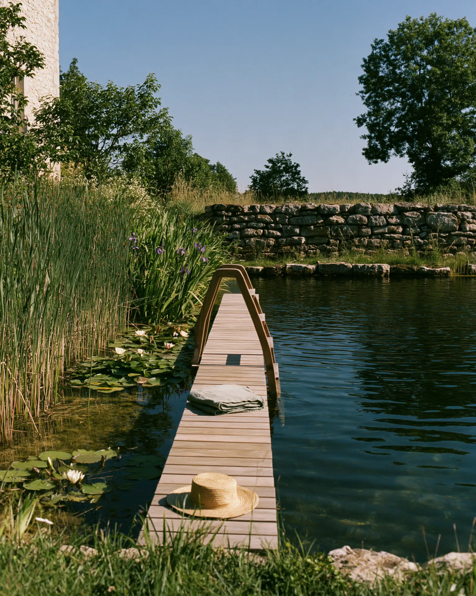 Natural swimming pond with a wooden pontoon