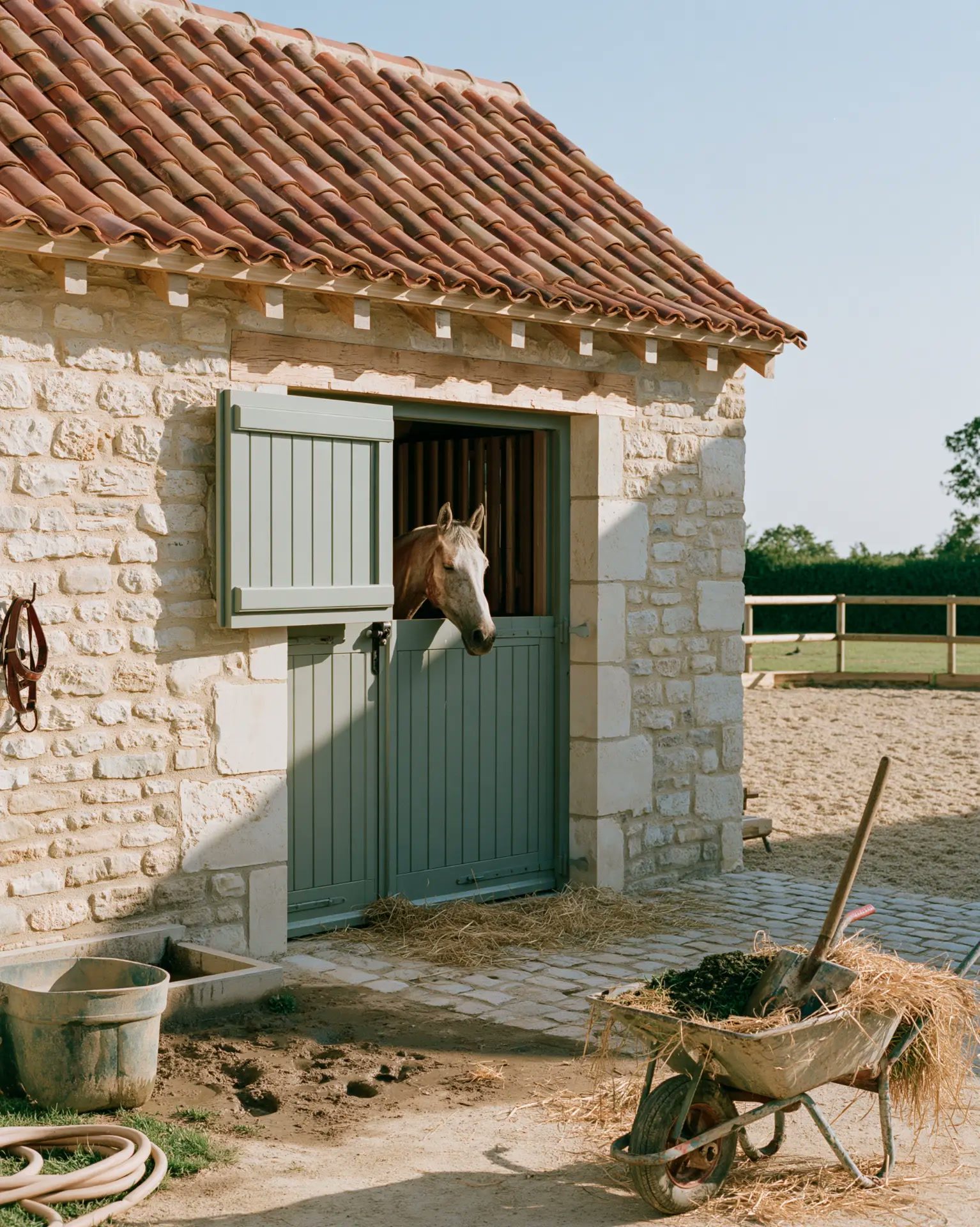 Restored stables, a horse at its door